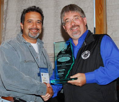 Greg Jeffery, district representative for Edmonton District (right), presents a Local Public Relations trophy to Mark Ramsankar, president of the Edmonton Public local.